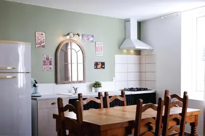 a kitchen with a wooden table and a refrigerator at Gîte proche du canal du midi et Narbonne 2 chambres in Mirepeisset