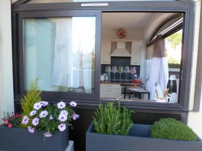 a window of a kitchen with flowers in pots at La Pergola de la Plage in Gruissan