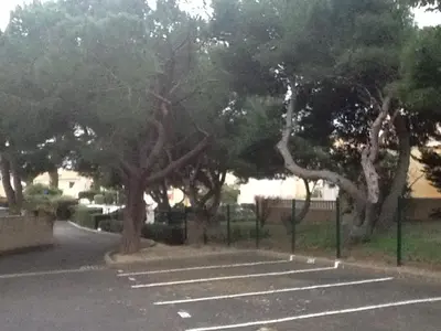 a parking lot with a bunch of trees at La Pergola de la Plage in Gruissan