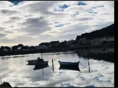 two boats sitting in the water on a lake at La Pergola de la Plage in Gruissan