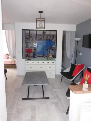 a living room with a dresser and a table at La Pergola de la Plage in Gruissan