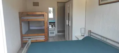 a small room with a bunk bed and a bathroom at Gite Rouge à la mer climatisation dans toutes les pièces in Port-la-Nouvelle