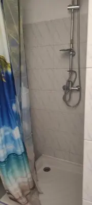 a shower with a shower curtain in a bathroom at Gite Rouge à la mer climatisation dans toutes les pièces in Port-la-Nouvelle