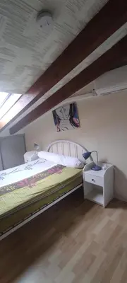 a bedroom with a large bed and a night stand at Gite Rouge à la mer climatisation dans toutes les pièces in Port-la-Nouvelle