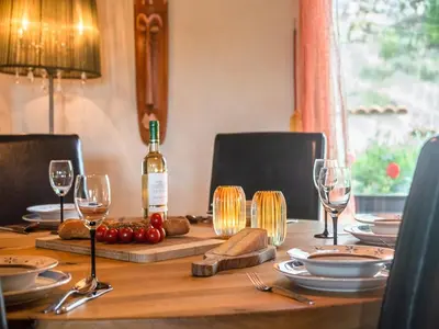 a wooden table with a bottle of wine and glasses at Charming French Villa with Pool in Cébazan
