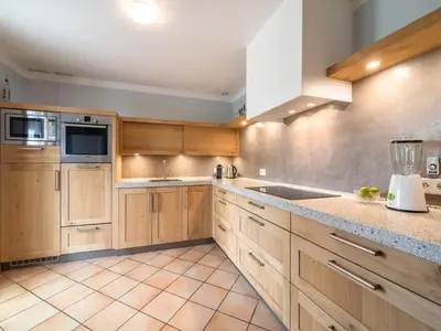 a kitchen with wooden cabinets and a sink at Charming French Villa with Pool in Cébazan