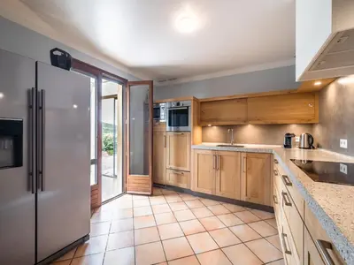 a kitchen with wooden cabinets and a refrigerator at Charming French Villa with Pool in Cébazan