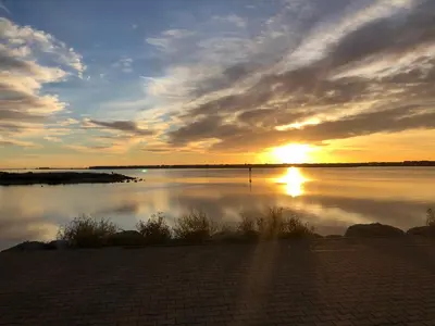 a sunset over a large body of water at T 3 appart les jardins du phœbus in Gruissan