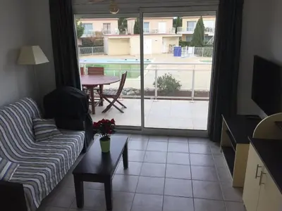a living room with a couch and a table at T 3 appart les jardins du phœbus in Gruissan