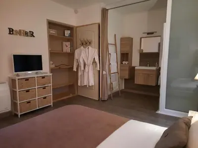 a room with a bedroom with a dresser and a mirror at 15min de la Cité de Carcassonne dans petit village, chambre au calme, petit-déjeuner et jacuzzi en supplément in Carcassonne