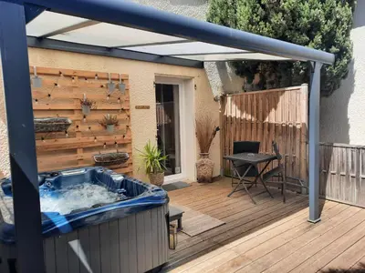 a patio with a hot tub on a wooden deck at 15min de la Cité de Carcassonne dans petit village, chambre au calme, petit-déjeuner et jacuzzi en supplément in Carcassonne