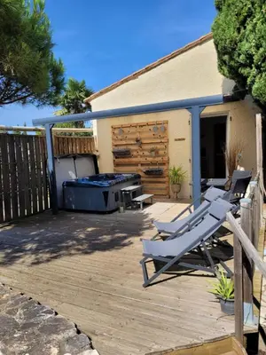 a patio with two lounge chairs and a grill at 15min de la Cité de Carcassonne dans petit village, chambre au calme, petit-déjeuner et jacuzzi en supplément in Carcassonne