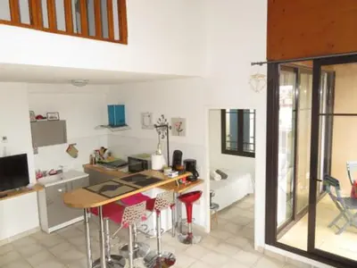 a kitchen with a table and chairs in a room at Gruissan Village APPT Duplex 51m2 in Gruissan
