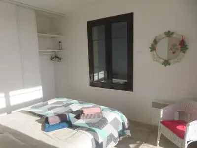 a bedroom with a bed with a blanket and a mirror at Gruissan Village APPT Duplex 51m2 in Gruissan