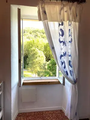 a window with a curtain in a room at Chez Providence Chambres et Table d'Hôtes in Cuxac-Cabardès