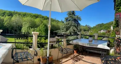 a patio with a table and chairs and an umbrella at Chez Providence Chambres et Table d'Hôtes in Cuxac-Cabardès