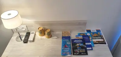 a table with books and other items on it at Hôtel L'Alsace in Narbonne