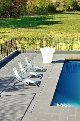 a group of chairs sitting next to a swimming pool at Relais Fasthotel Port Lauragais in Avignonet-de-Lauragais