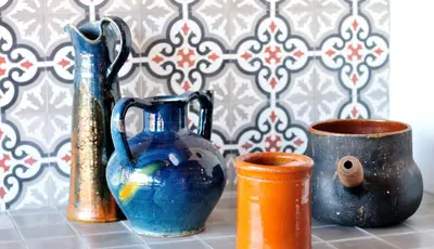 three vases sitting on a table next to a cup at Relais Fasthotel Port Lauragais in Avignonet-de-Lauragais