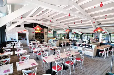 a restaurant with white tables and red chairs at Relais Fasthotel Port Lauragais in Avignonet-de-Lauragais
