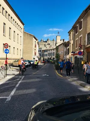a group of people riding bikes down a city street at Au pied de la Cité in Carcassonne