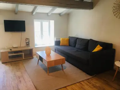 a living room with a blue couch and a coffee table at Au pied de la Cité in Carcassonne