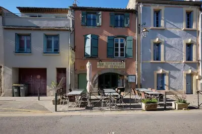 a building with tables and chairs in front of a building at Au pied de la Cité in Carcassonne