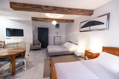 a bedroom with two beds and a table and a desk at Chambre Familiale du Couvent in Narbonne