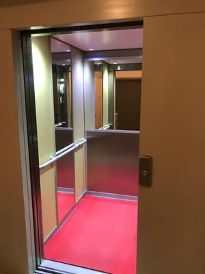 an empty corridor with a red carpet in a building at Chambre Familiale du Couvent in Narbonne