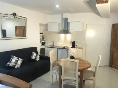 a living room with a black couch and a table at Chambre Familiale du Couvent in Narbonne