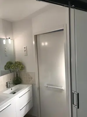 a bathroom with a glass shower door next to a sink at Chambre Familiale du Couvent in Narbonne