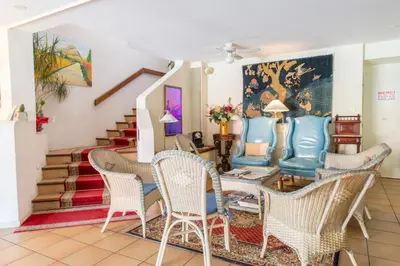a living room with chairs and a table and stairs at Hôtel du Canal in Castelnaudary