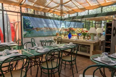 a dining room with tables and chairs and a large window at Hôtel du Canal in Castelnaudary