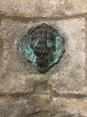 a statue of a lion head on a stone wall at Le Clos Saint Michel in Carcassonne