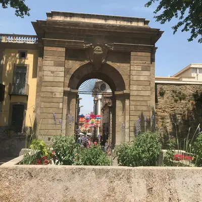 a stone archway with flowers in front of a building at Le Clos Saint Michel in Carcassonne