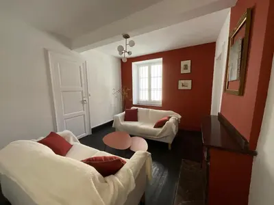 a living room with red walls and white furniture at Le Clos Saint Michel in Carcassonne