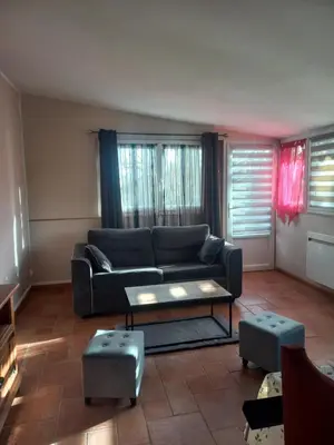 a living room with a couch and a table at gite tout confort in Montolieu