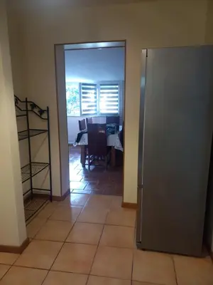 a kitchen and dining room with a table and a refrigerator at gite tout confort in Montolieu