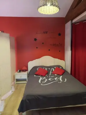a bedroom with a bed with red walls and black stars at gite tout confort in Montolieu