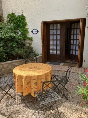 a table and chairs in front of a building at L'Ecurie in Paziols