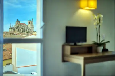 a room with a view of a building through a window at Zenitude Hôtel-Résidences Narbonne Centre in Narbonne