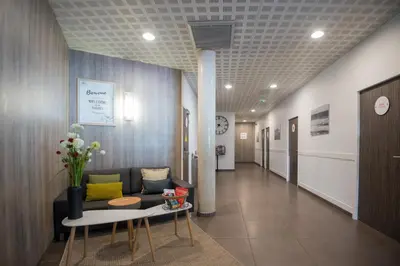 a hospital hallway with a couch and a table at Zenitude Hôtel-Résidences Narbonne Centre in Narbonne