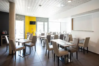 a dining room with wooden tables and chairs at Zenitude Hôtel-Résidences Narbonne Centre in Narbonne