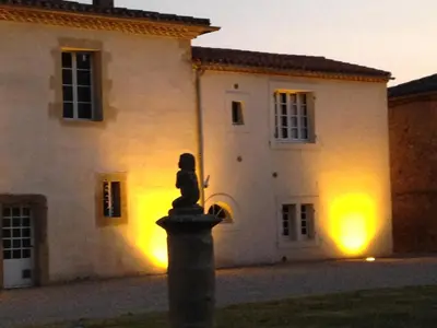 a statue in front of a building at night at La Ginelle - Appartement Guy in Airoux