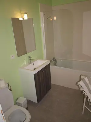 a bathroom with a sink and a toilet and a tub at La Ginelle - Appartement Guy in Airoux