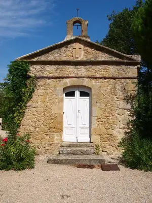 a small stone building with a white door at La Ginelle - Appartement Bocage in Airoux