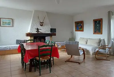 a living room with a table and a couch at La Ginelle - Appartement Bocage in Airoux