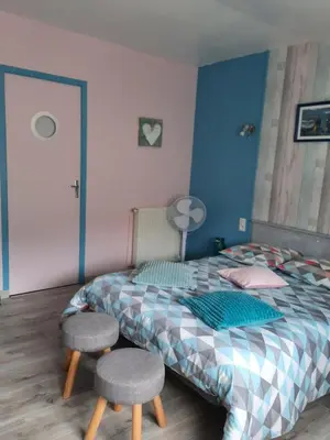 a bedroom with a bed with two stools in it at L'Amandier in Maury