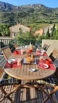 a wooden table with food on top of a deck at L'Amandier in Maury
