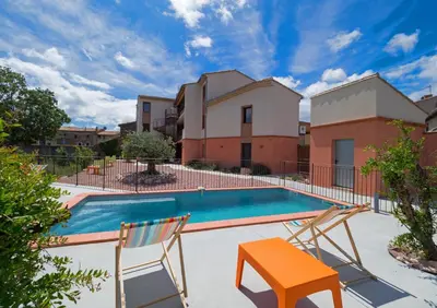 a patio with two chairs and a swimming pool at Logis Hotel - Restaurant La Marbrerie in Caunes-Minervois